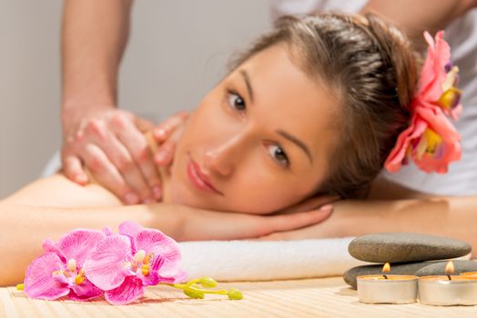 candles, stones and flowers for spa treatments and the girl's face out of focus