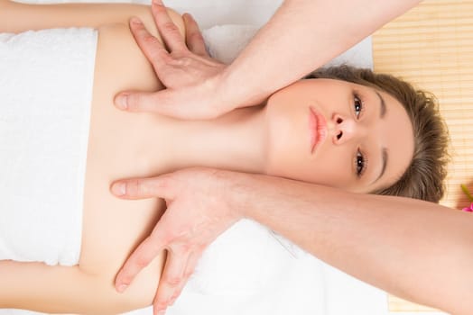 portrait of a woman during the massage of the neck and shoulders in the salon beautician