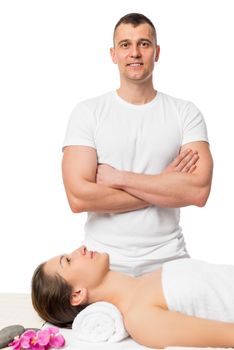 successful massage therapist and a girl on a massage table isolated on white