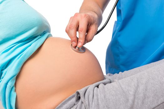 Doctor using stethoscope listening pregnant woman's belly