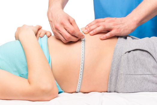 gynecologist Doctor measures the volume of the abdomen a measuring tape