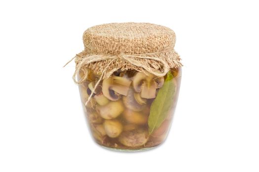 Pickled button mushrooms in glass jar on a light background
