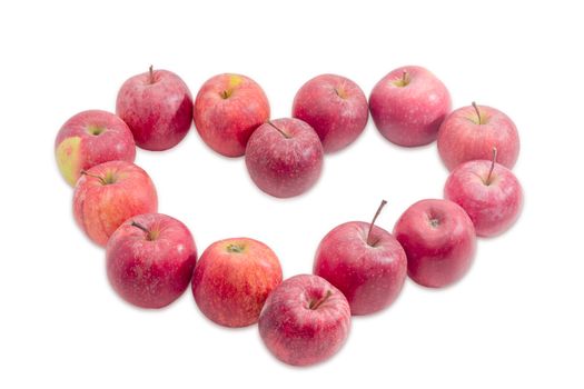 Fresh red apples, laid out in the shape of heart on a light background
