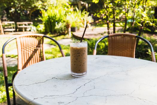 ice coffee in glass on table in the garden