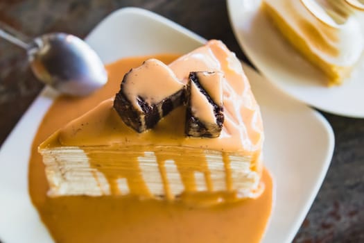 crepe cake with milk tea sauce on white dish