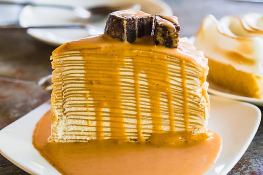 crepe cake with milk tea sauce on white dish