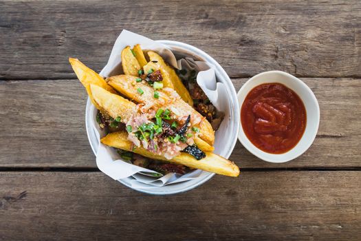 top view of fresh fried french fries with ketchup on wood table