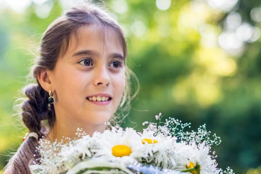 girl with a bouquet of daisies in the Park