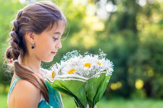 girl with a bouquet of daisies in the Park