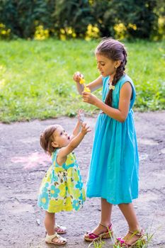 little girl catches bubbles in the Park