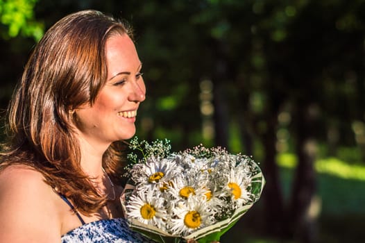 woman with a bouquet of daisies in the Park