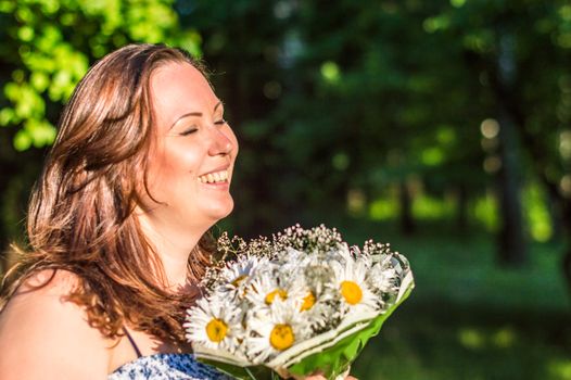 woman with a bouquet of daisies in the Park