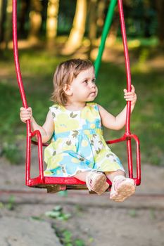 little girl swinging on a swing in the Park