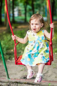 little girl swinging on a swing in the Park