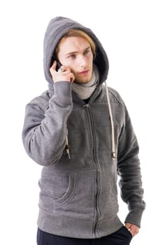 Attractive young man in winter clothes talking on cellphone, having a conversation, isolated on white