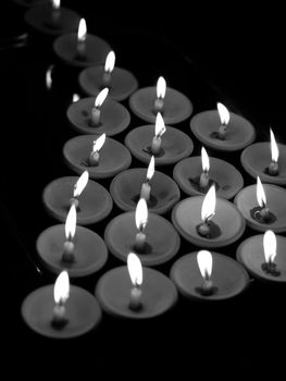 BLACK AND WHITE PHOTO OF OFFERING LIT CANDLES