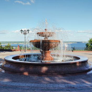 Fountain with granite bowl on the embankment of the Volga river in Ulyanovsk in the summer