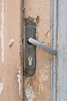 Old ragged door and rusty lock