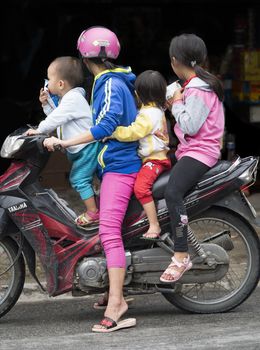 Hoi An, Vietnam - Dec 27, 2016: Biker family in Hoi An. Motor bikes are the most popular form of transport in Vietnam.