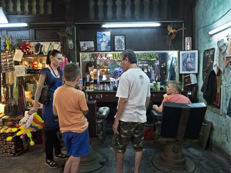 Hoi An, Vietnam - Dec 27, 2016: Tourist family in Hoi An Barber shop asking for the most popular vietnamese hair styles.