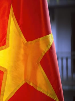 close up of red vietnamese flag with buildings background
