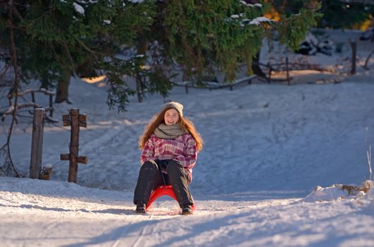 Happy girl sliding up in winter