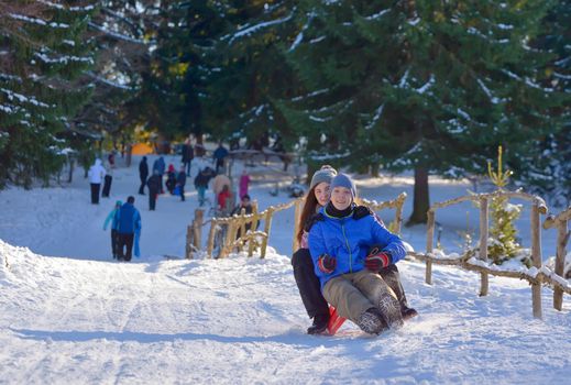 Teenagers slide downhill in wintertime