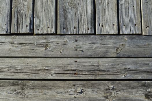 Silvery worn wood planks run both horizonally and vertically as a background with character