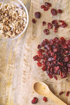 Dried cranberries in the glass bowl on the wooden table top view