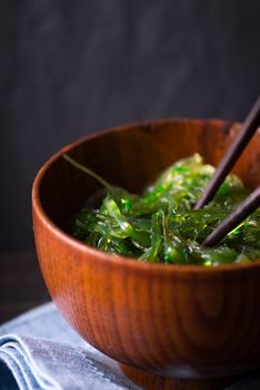 Chuka salad  in the wooden bowl  on the dark background