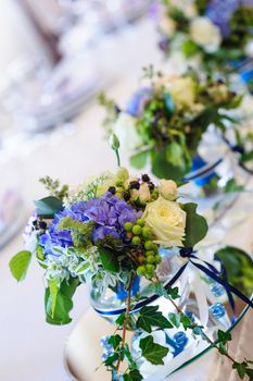 wedding decor of lilac flowers on the tables in the restaurant.