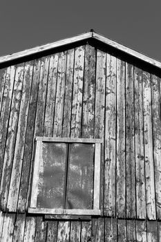 An abstract closeup of a traditional old Ontario barn, that was black and is weathered and the boards lit up by sunshine.