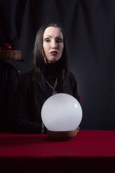 Fortune teller with a magic ball on a black background