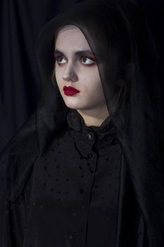 Young girl vampire on a black background