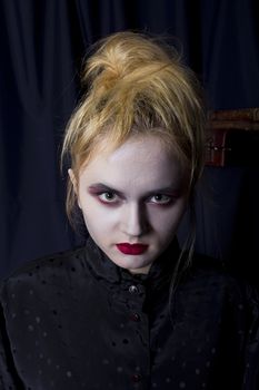 Young girl vampire on a black background