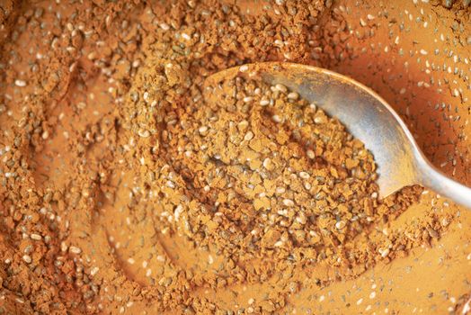Cocoa powder and chia seeds mix with spoon background close-up