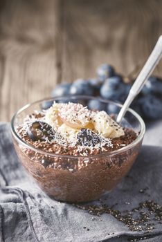 Chocolate chia pudding in the glass bowl vertical
