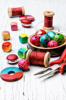 different loose beads for jewelry and pliers on light background
