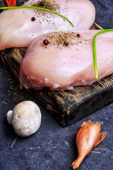 chicken raw fillets on kitchen plate with spices and mushrooms