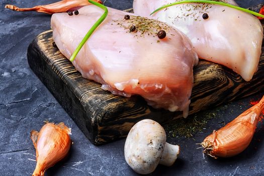 chicken raw fillets on kitchen plate with spices and mushrooms