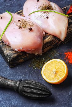 chicken raw fillets on kitchen plate with spices and mushrooms