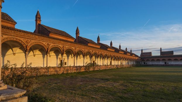 Grand Cloister of the Certosa di Pavia monastery,features columns with precious decorations in terracotta portraying saints, prophets and angels, in white and pink Verona marble,at sunset,Italy.