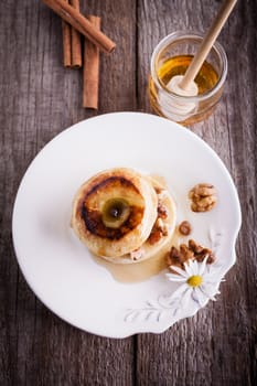 Baked apple with nuts and raisins on a wooden surface