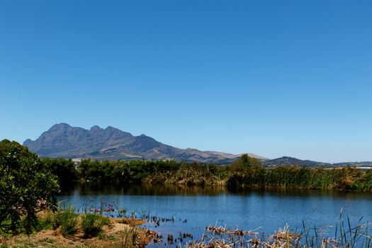 The dam, Bushes and Mountain View with Blue Skies.