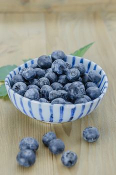 Blueberries in a bowl on a wooden background