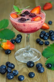 Raspberry smoothie with fresh berries on a wooden table