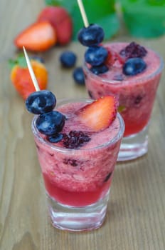 Raspberry smoothie with fresh berries on a wooden table