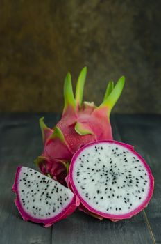 Ripe Dragon fruit or Pitaya with slice on wooden background , still life