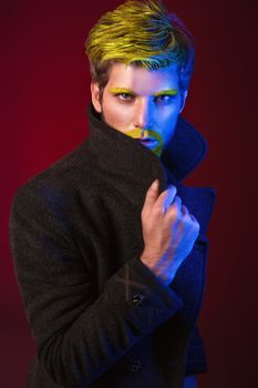 Fashion Art Photo of Handsome Young Man in the Light Colored Spotlights.