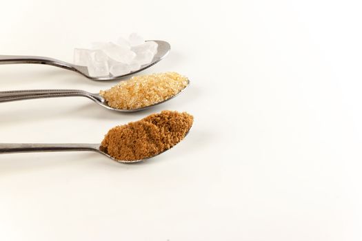 Brown cane sugar in a metal spoon on the white background. Pure cane sugar for natural. no additives.